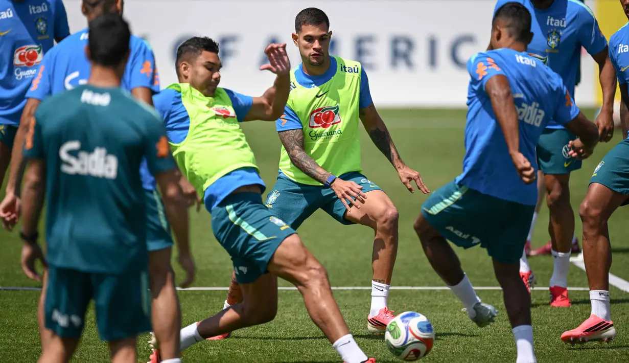 Gelandang Brasil Casemiro (kiri) dan Bruno Guimaraes (tengah) berebut bola selama sesi latihan sebagai bagian dari persiapan menghadapi pertandingan sepak bola Piala Dunia 2026 melawan Maroko di Fasilitas Latihan Columbia Park, Morristown, New Jersey, pada 9 Juni 2026. (MAURO PIMENTEL/AFP)