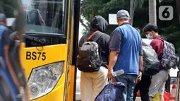 Sejumlah pasien COVID-19 masuk ke dalam bus sekolah yang akan mengantarkan mereka menuju RSDC Wisma Atlet di Puskesmas Kecamatan Tebet, Jakarta, Kamis (3/2/2022). Satgas Penanganan COVID-19 mencatat kenaikan kasus positif COVID-19 dalam satu pekan terakhir. (Liputan6.com/Herman Zakharia)