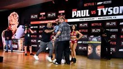 Mike Tyson mendorong Jake Paul di atas panggung saat melakukan faceoff. (Roy Rochlin / GETTY IMAGES NORTH AMERICA / Getty Images via AFP)