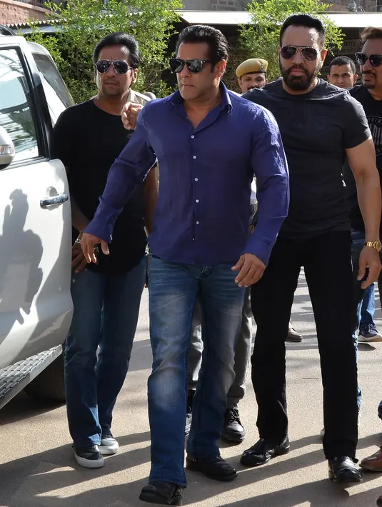 Aktor Bollywood didampingi kenalannya saat tiba di sebuah pengadilan di Jodhpur, India (7/5). Atas kasus tersebut aktor berusia 52 tahun ini pun dijatuhi hukuman selama lima tahun penjara. (STR/AFP)