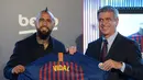Pemain baru Barcelona, Arturo Vidal (kiri) berpose dengan Wakil Presiden Barcelona Jordi Mestre dalam presentasi resminya di Stadion Camp Nou, Barcelona, Spanyol, Senin (6/8). (Josep LAGO/AFP)