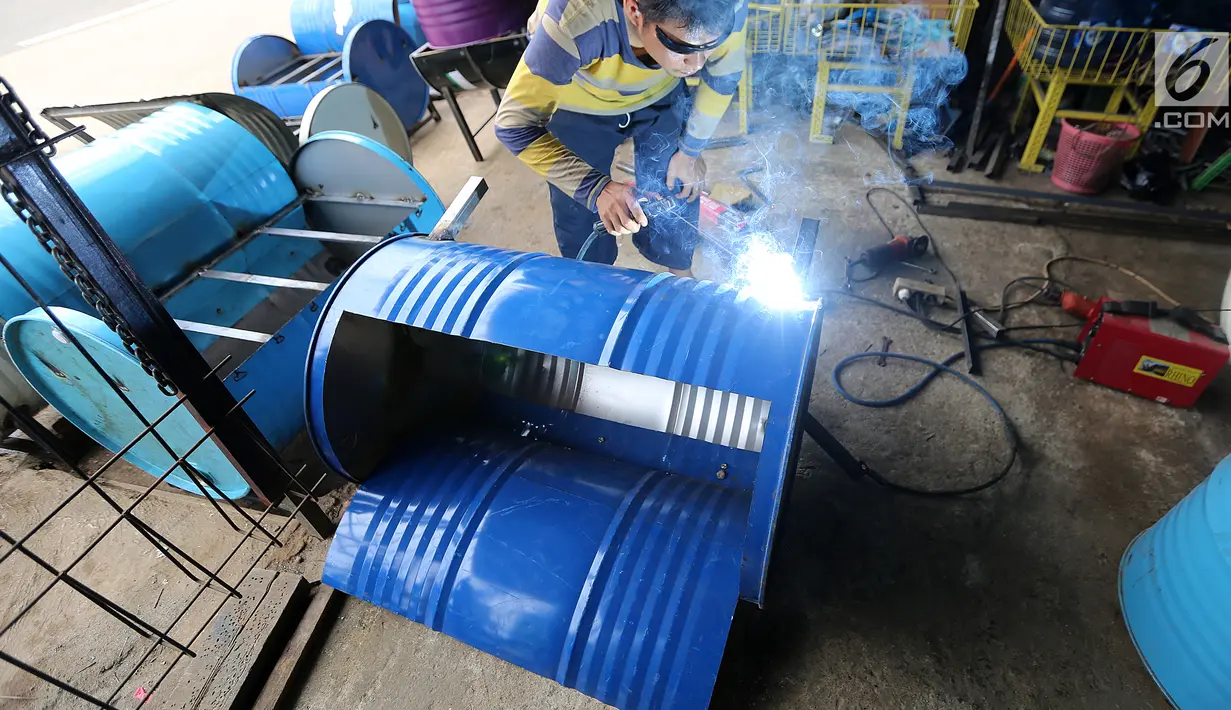 Pekerja sedang mengelas drum bekas untuk bahan membuat kursi di industri kecil Ali Kreatif, Parung Bogor, Selasa (30/1). Industri yang beromset 20 juta rupiah setiap minggunya juga memproduksi tempat sampah, lemari hingga meja. (Liputan6.com/Fery Pradolo)