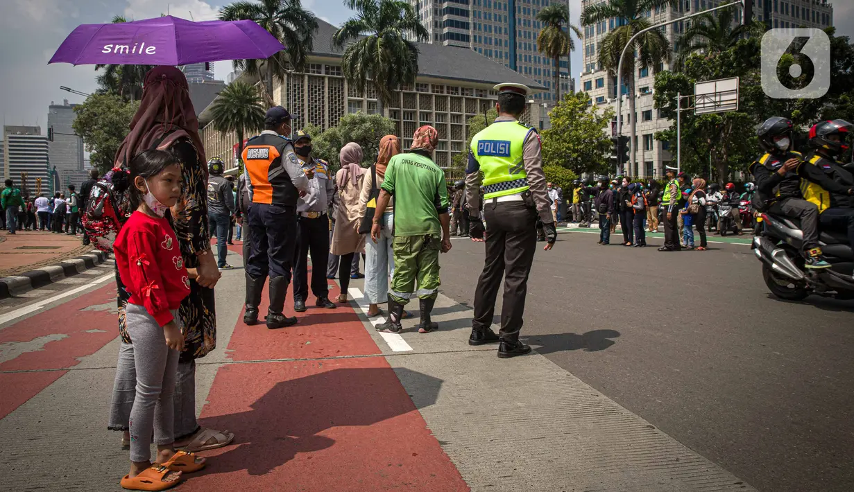 Antusias warga menyaksikan parade pembalap MotoGP di kawasan Jakarta, Rabu (16/3/2022).  Gelaran parade MotoGP di Jakarta dalam rangka penyambutan event MotoGP Mandalika 2022. (Liputan6.com/Faizal Fanani)