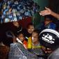 Nampak seorang ibu hamil dengan anak balita tengah mendapatkan pertolongan warga akibat banjir di kawasan Garut Kota, kabupaten Garut, Jawa Barat. (Liputan6.com/Jayadi Supriadin)