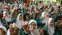 Pemerintah Kabupaten Sidoarjo mengajak ribuan anak makan telur untuk peringati Hari Pangan Sedunia ke-39 pada Kamis, 21 November 2019. (Foto: Liputan6.com/Dian Kurniawan)