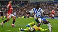 Kiper Manchester United, Andre Onana, saat mematahkan serangan Brighton and Hove Albion yang dibangun gelandang Yankuba Minteh, pada laga pekan kedua Premier League di&nbsp;American Express Stadium, Sabtu (24/8/2024) malam WIB. (AFP/Glyn Kirk)