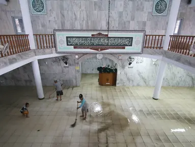 Warga bergotong royong membersihkan banjir yang menggenangi Mesjid An Nur di kawasan Pasar Minggu, Jakarta, Selasa (4/10). Banjir yang rutin menggenangi kawasan tersebut menyebabkan aktivitas warga serta ibadah terganggu. (Liputan6.com/Immanuel Antonius)