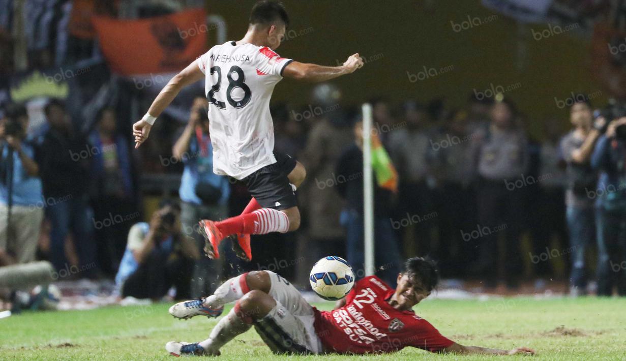 Pemain Bali United, Ganjar Mukti melakukan tackling saat berebut bola dengan pemain Persija Jakarta, Rezaldi Hehanusa pada laga Trofeo Persija di Stadion Utama Gelora Bung Karno, Jakarta, Sabtu (9/4/2016). (Bola.com/Nicklas Hanoatubun)