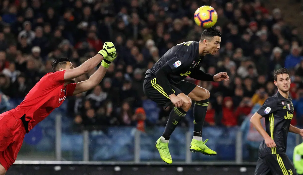 Penyerang Juventus, Cristiano Ronaldo berebut  bola dengan kiper Lazio, Thomas Strakosha pada pekan ke-21 Serie A di Stadion Olimpico, Minggu (27/1). Sempat tertinggal, Ronaldo membawa Juventus menang 2-1 atas Lazio. (AP/Gregorio Borgia)