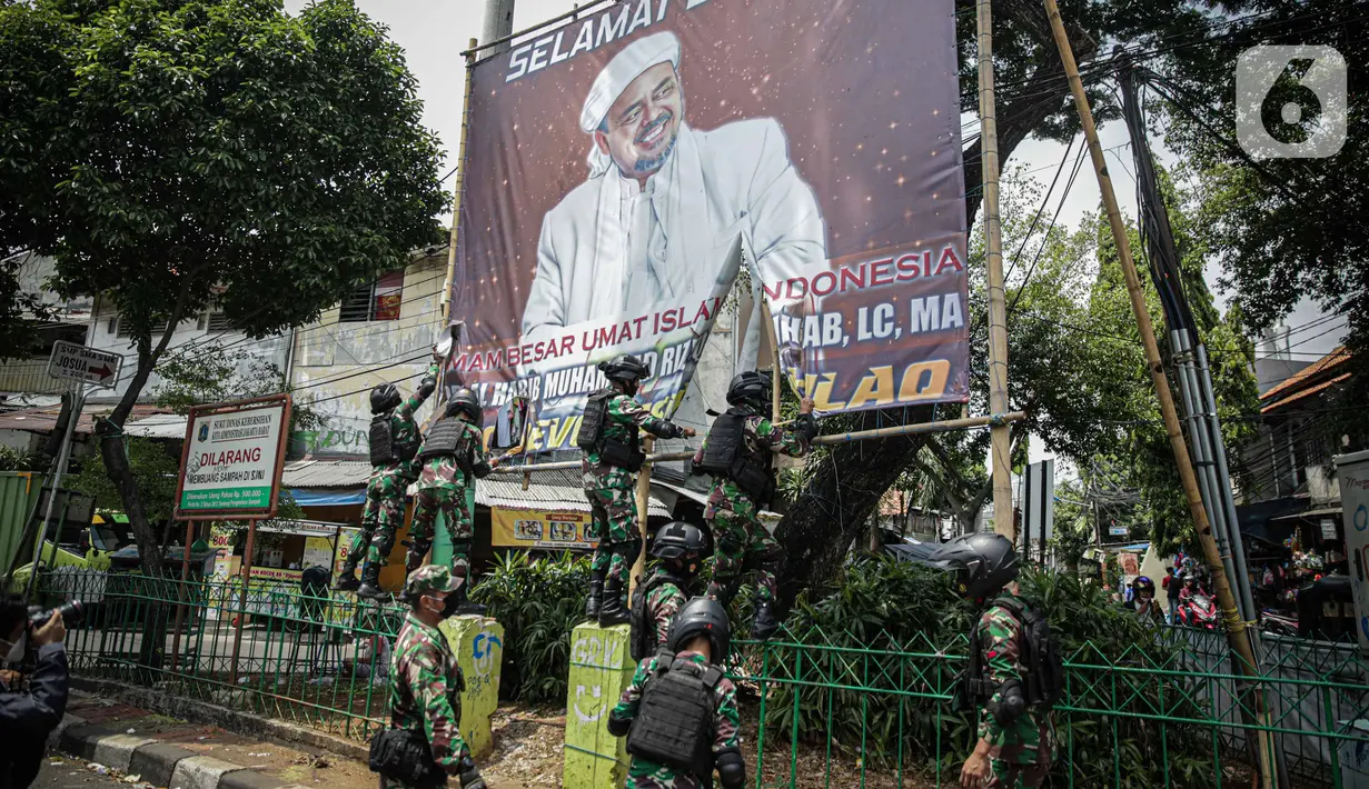 Anggota TNI mencopot paksa baliho Rizieq Shihab yang terpasang di sekitar kawasan Petamburan, Jakarta, Jumat (20/11/2020). Pencopotan dilakukan karena menyalahi aturan yang telah ditetapkan. (Liputan6.com/Faizal Fanani)