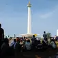 Sejumlah pengunjung beristirahat di bawah pohon yang ada di sekitar areal Monumen Nasional, Jakarta, Jumat (1/1/2016). Hari libur tahun baru 2016 dimanfaatkan ribuan warga untuk berwisata di kawasan Monumen Nasional. (Liputan6.com/Helmi Fithriansyah)