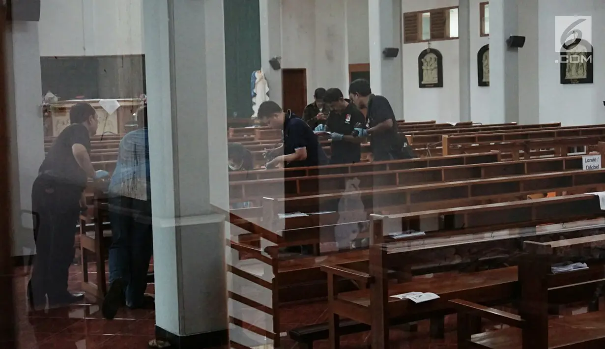 Polisi mengambil gambar saat melakukan olah tempat kejadian perkara (TKP) penyerangan yang terjadi di Gereja Santa Lidwina Bedog, Trihanggo, Sleman, Yogyakarta, Minggu (11/2). Polisi masih mendalami motif penyerangan tersebut. (Liputan6.com/Arya Manggala)