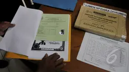 Petugas memeriksa berkas seorang narapidana LP Cipinang yang ikut menjalani UN melalui program Paket C di LP Narkotika Cipinang, Jakarta, Senin (13/4/2015).  Para peserta terlihat bersemangat menjalani UN 2015. (Liputan6.com/Johan Tallo)