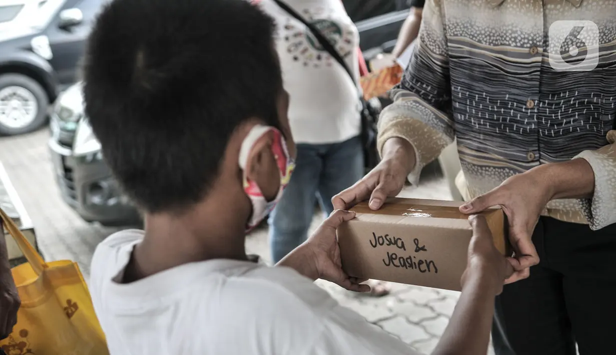 Seorang anak menerima donasi ponsel yang diberikan oleh Komunitas #WartawanLintasMedia saat acara #PonselPintarUntukPelajar di Jakarta, Minggu (9/8/2020). (merdeka.com/Iqbal S. Nugroho)