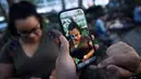 Karakter Pokemon muncul di sebelah seorang wanita saat bermain augmented reality Pokemon Go di Bryant Park, New York City, Amerika Serikat, 11 Juli 2016. Demam Pokemon Go sedang mewabah di kalangan para gamers ponsel cerdas. (REUTERS/Mark Kauzlarich)