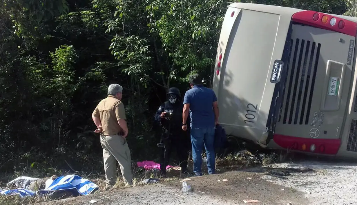 Petugas kepolisian dan paramedis memeriksa lokasi kecelakaan sebuah bus wisata yang terbalik di Quintana Roo, Meksiko, Selasa (19/12). Sebanyak 7 korban luka merupakan warga negara AS dan dua lainnya berkebangsaan Swedia. (Manuel Jesús ORTEGA CANCHE/AFP)
