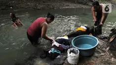 Warga mencuci pakaian di aliran Kali Cihoe, Cibarusah, Kabupaten Bekasi, Jawa Barat, Rabu (19/7/2023). Warga memanfaatkan Kali Cihoe untuk mandi dan mencuci pakaian saat musim kemarau karena sumur mereka kekeringan. (merdeka.com/Imam Buhori)