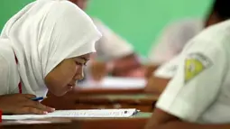 Seorang pelajar SMP serius membaca soal ujian saat mengikuti ujian nasional (UN) di SMP 1 Semen, Kediri, Jawa Timur, Senin (23/4). Sebanyak 3.740.043 siswa SMP/MTs/SMPLB/SMPT seluruh Indonesia mengikuti UN untuk menentukan kelanjutan pendidikan ke jenjang berikutnya. (Antara)