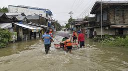 Penjaga pantai dan personel polisi mengevakuasi seorang penduduk dari daerah banjir di Kota Abuyog, Provinsi Leyte, Filipina, 11 April 2022. Banjir terjadi menyusul hujan lebat yang disebabkan oleh badai tropis Agaton. (Philippine Coast Guard (PCG)/AFP)