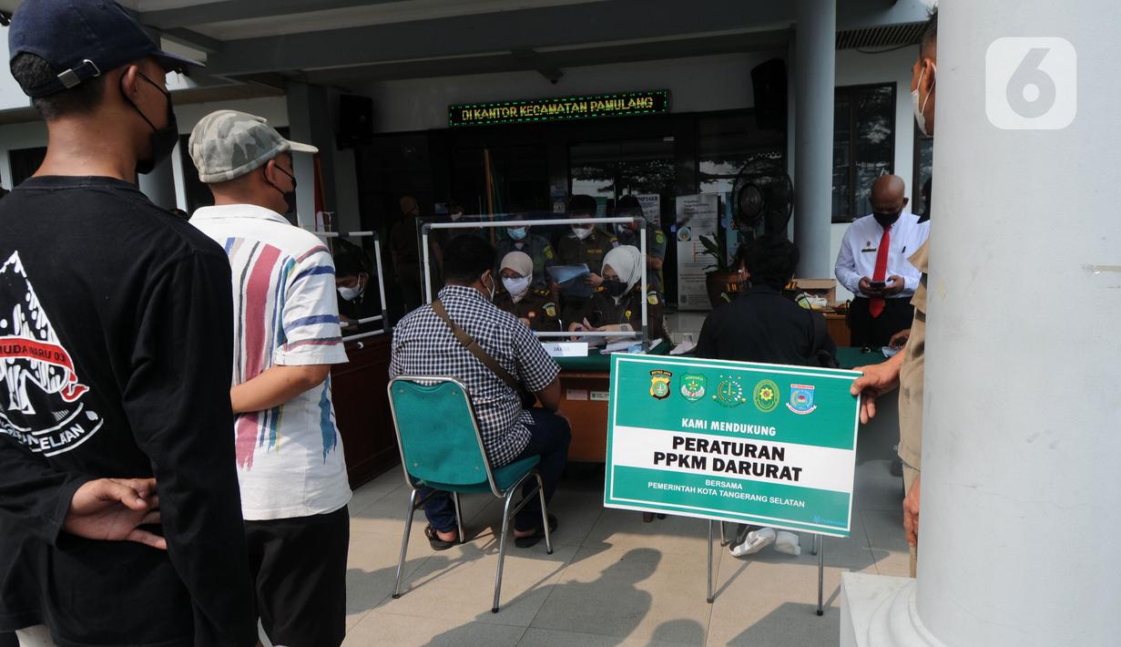 Pelanggar membayar denda saat Sidang Tipiring PPKM Darurat di kantor Kecamatan Pamulang, Tangerang Selatan, Banten, Senin (19/7/2021). Dua puluh empat pelanggar PPKM Darurat diantaranya tidak bermasker dan jam operasional tempat usaha didenda Rp 100 ribu hingga Rp 500 ribu. (merdeka.com/Arie Basuki)