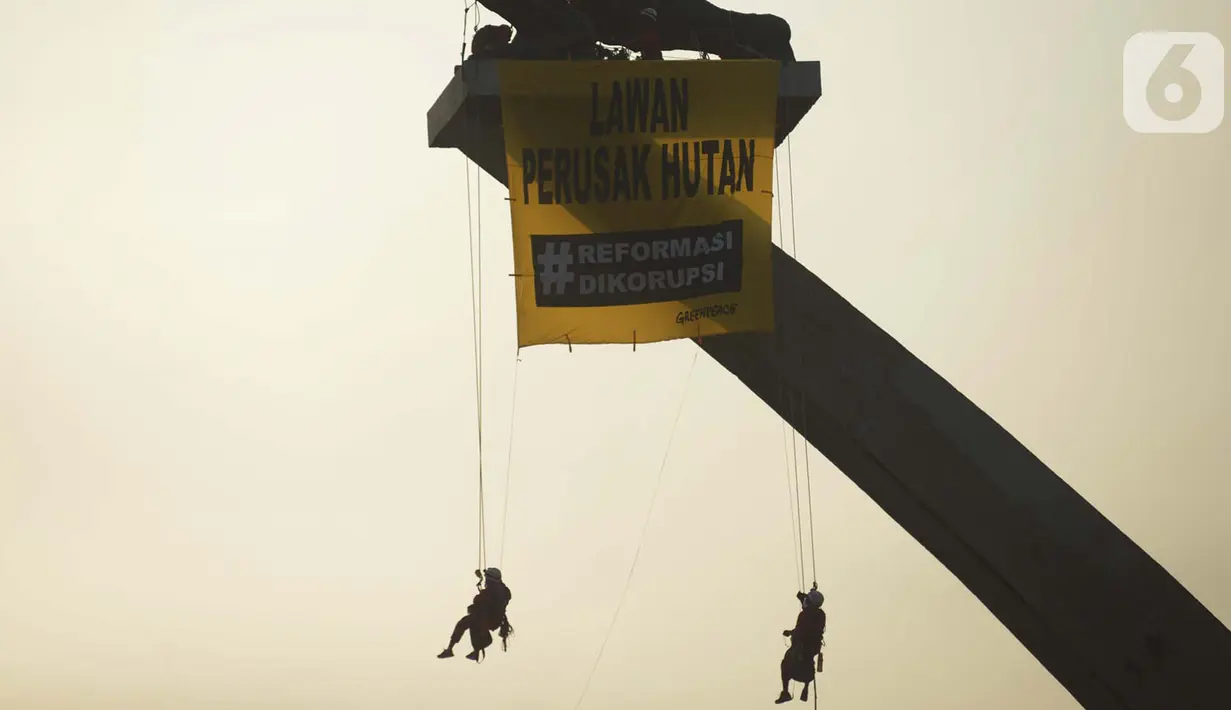 Sejumlah orang membentangkan spanduk di Patung Dirgantara Pancoran, Jakarta, Rabu (23/10/2019). Aksi tersebut juga menyerukan pesan kepada Presiden Joko Widodo atau Jokowi untuk segera melakukan penyelamatan hutan. (merdeka.com/Imam Buhori)