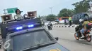 Anggota kepolisian memperingati pengguna kendaraan bermotor untuk mengurangi kecepatan karna pemisah jalan anatara roda dua dan roda empat di jalan Lamaran, Karawang, Jawa Barat, Minggu (3/7).(Liputan6.com/Gempur M Surya)