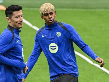 Pemain Barcelona, Lamine Yamal (kanan) dan Robert Lewandowski tampak dalam latihan menjelang laga leg 2 semifinal Liga Champions 2024/2025 melawan Inter Milan di Giuseppe Meazza, Milan, Italia. (AFP/Piero Cruciatti)