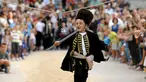 Seorang anak berlari memasukkan tombak kedalam lubang sasaran selama turnamen tradisional Alka di desa Vuckovici, Kroasia, Minggu (23/8/2015). Turnamen ini memperingati kemenangan Kroasia atas pemerintahan Turki Ottoman. (REUTERS/Antonio Bronic) 