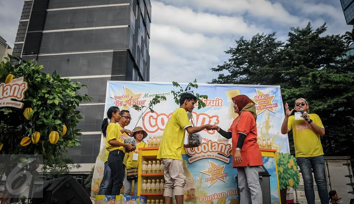Erni Fitratunissa selaku Kepala Bidang Pelestarian & Tata Lingkungan BPLHD memberikan bibit pohon belimbing kepada peserta Car Free Day disela acara Coolant Star Fruit, Jakarta, Minggu (25/9). (Liputan6.com/Faizal Fanani)