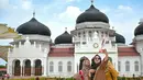 <p>Sejumlah wisatawan memadati halaman Masjid Raya Baiturrahman saat libur lebaran Idulfitri 1444 H di Banda Aceh, Aceh, Selasa (25/4/2023). (AFP/CHAIDEER MAHYUDDIN)</p>