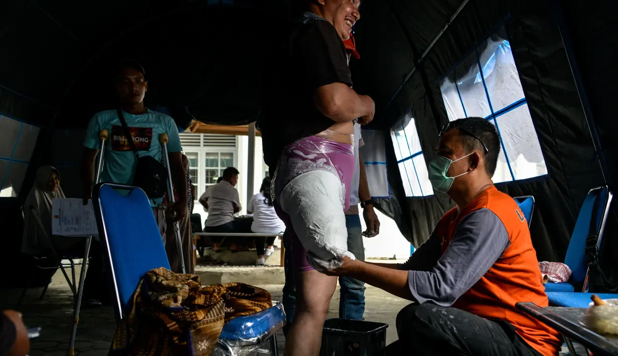 Petugas mengukur dan mencetak kaki palsu untuk seorang penyandang disabilitas di kantor Dinas Sosial Aceh, Senin (16/9/2019). Untuk tahun 2019 ini diberikan secara gratis sebanyak 100 kaki dan tangan palsu untuk para penyandang disabilitas di sejumlah kabupaten/kota. (CHAIDEER MAHYUDDIN / AFP)