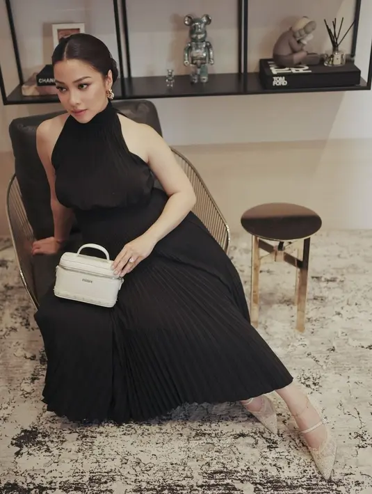 Di potret ini, Nikita Willy tampil glamor dengan halter pleated dress. Dipadukan dengan lace shoes dan hand bag putih [@nikitawillyofficial94]