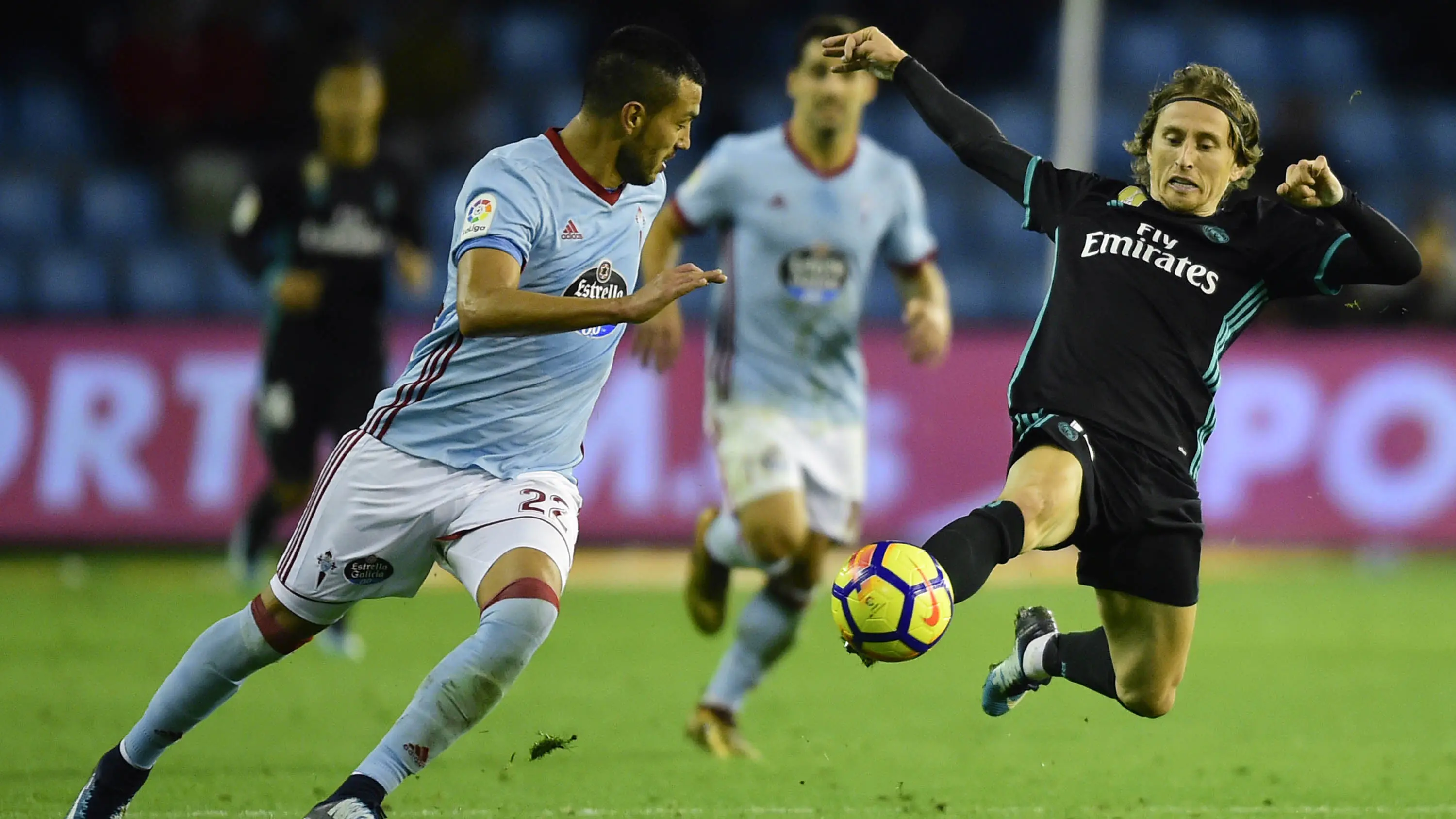 Gelandang Real Madrid, Luka Modric, berebut bola dengan bek Celta Vigo, Gustavo Cabral, pada laga La Liga Spanyol di Stadion Balaidos, Vigo, Minggu (7/1/2018). Kedua klub bermain imbang 2-2. (AFP/Miguel Riopa)