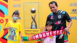 Warga dengan antusias berfoto bersama trofi Piala Dunia U-17 2023 saat Hari Bebas Kendaraan Bermotor di kawasan Bundaran HI, Minggu (15/10/2023). (Bola.com/Bagaskara Lazuardi)