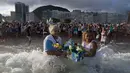 Penganut kepercayaan Afro-Brasil melarung persembahan untuk Dewi Laut, Yemanja dalam tradisi upacara menjelang tahun baru di pantai Copacabana, Rio de Janeiro, Sabtu (29/12). Ritual dilakukan untuk mendapat berkat di tahun yang akan datang (AP/Leo Correa)