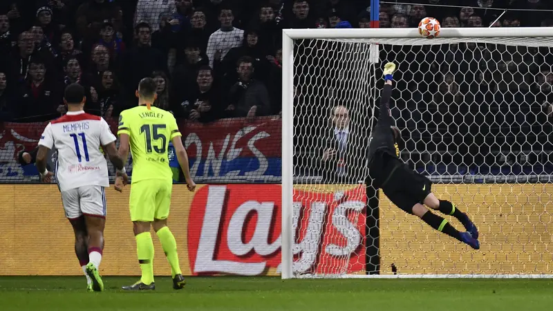 Aksi penyelamatan kiper Barcelona, Marc-Andre ter Stegen saat duel lawan Lyon di Liga Champions, Selasa (19/2). (AFP/Jeff Pachoud)