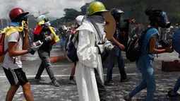 Demonstran anti- Nicolas Maduro memegang botol tinja untuk dilemparkan ke polisi anti huru-hara di Caracas, Venezuela, 10 Mei 2017. Mereka kini menggunakan bom 'poopootov' untuk menyerang petugas yang menghalangi jalannya demo. (AP Photo/Ariana Cubillos)