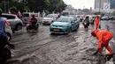 Sejumlah kendaraan melintasi genangan air usai hujan deras dikawasan Tugu Tani, Jakarta, Kamis (12/10). Agar tidak terjadi genangan kembali petugas dari Dinas Kebersihan membuang aliran air hujan kedalam selokan. (Liputan6.com/Faizal Fanani)