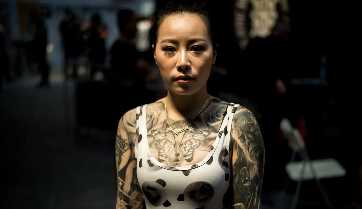 Seorang wanita berpose memperlihatkan tato diseluruh tubuhnya saat acara Langfang Internasional Tattoo di Hebei, China (29/5/2016). (AFP PHOTO / FRED Dufour)