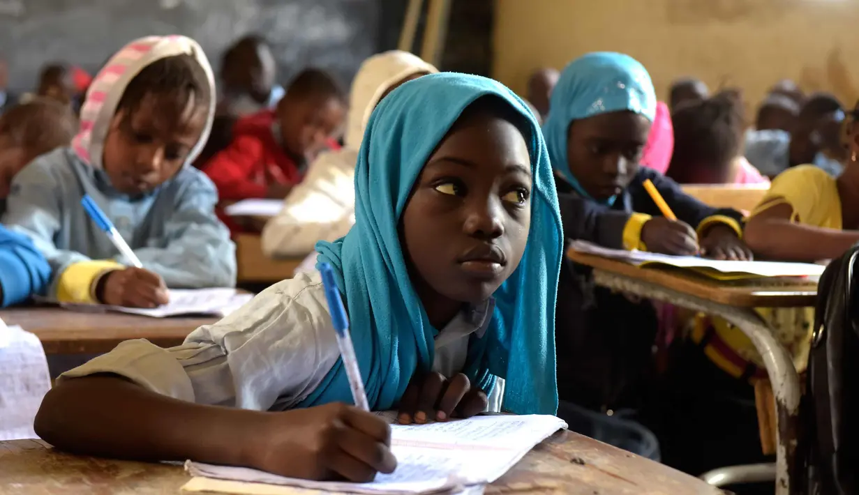 Ekspresi seorang murid saat menghadiri kelas di sekolah dasar di Pikine, di pinggiran Dakar, (30/1). Beberapa kepala negara, termasuk presiden Prancis dan Presiden Senegal mensponsori pertemuan tersebut. (AFP Photo/Seyllou)