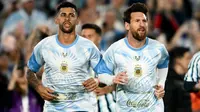 Penyerang Argentina bernomor punggung 10, Lionel Messi (kanan), dan bek bernomor punggung 13, Cristian Romero (kiri), memasuki lapangan untuk melakukan pemanasan menjelang pertandingan persahabatan internasional antara Argentina dan Benin di Stadion Mas Monumental, Buenos Aires, pada 7 Oktober 2026. (Luis ROBAYO/AFP)