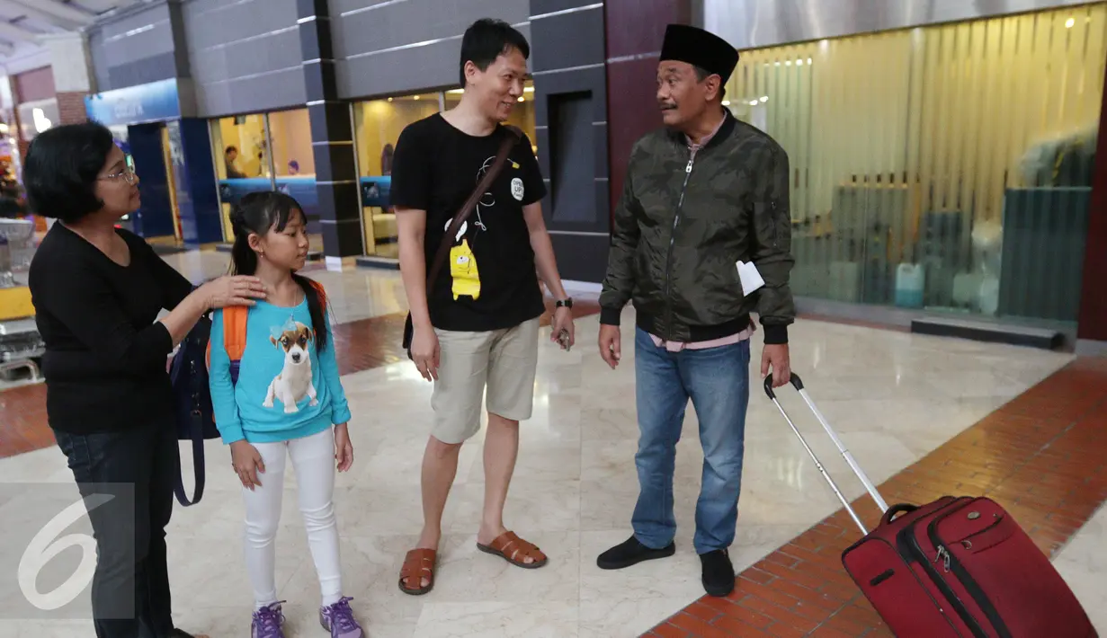  Cawagub DKI Jakarta, Djarot Saiful Hidayat berbincang dengan calon penumpang di Terminal 2E Bandara Soetta, Tangerang Minggu (25/12). Selama umroh dirinya akan mematikan semua gadget dan komunikasi. (Liputan6.com/Fery Pradolo)