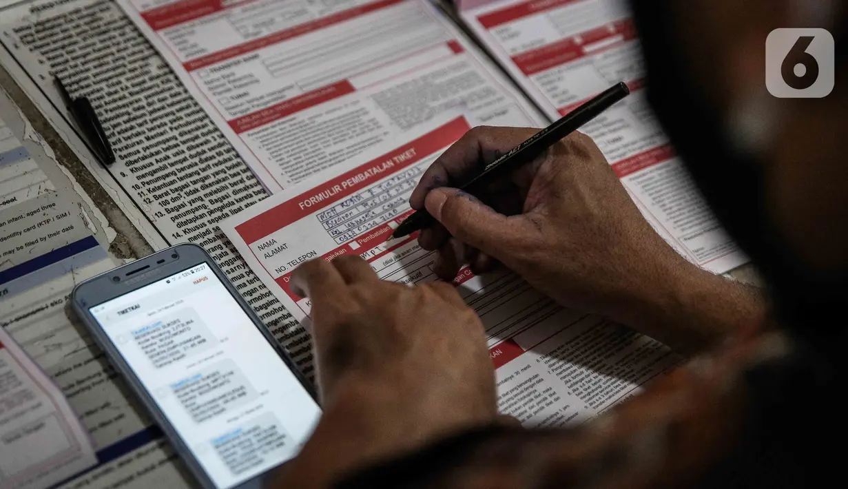 Calon penumpang mengisi formulir pembatalan tiket kereta di Stasiun Pasar Senen, Jakarta, Kamis (24/4/2020). Terkait dengan larangan mudik 2020, PT Kereta Api Indonesia akan melayani pembatalan tiket kereta dengan pengembalian dana 100 persen bagi penumpang. (Liputan6.com/Faizal Fanani)