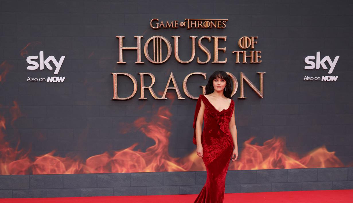 Olivia Cooke berpose di karpet merah saat tiba untuk menghadiri pemutaran perdana serial drama asli HBO "House of the Dragon" di Leicester Square Gardens, di London (15/8/2022). Olivia Cooke juga tampil memesona dengan memakai anting yang berkilau dengan gaun merahnya. (AFP/Hollie Adams)