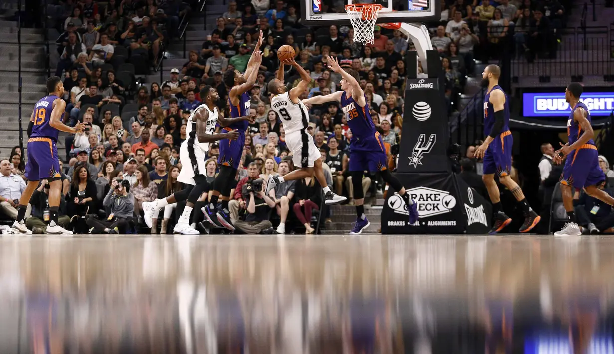 Pemain San Antonio Spurs, Tony Parker #9 mencoba melakukan tembakan melewati hadangan pemain Phoenix Suns, TJ Warren #1 dan Dragan Bender #35 pada laga NBA di AT&T Center, (28/12/2016). (Reuters/Soobum Im-USA TODAY Sports)