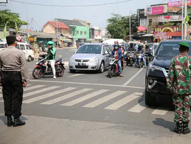 Aparat gabungan menghentikan laju kendaraan untuk mengajak masyarakat mengheningkan cipta di Kawasan Jalan RE Martadinata, Tangerang Selatan, Senin (17/8/2020). Kegiatan mengheningkan cipta ini dilakukan selama 3 menit dalam rangka memperingati HUT ke-75 RI. (Liputan6.com/Faizal Fanani)