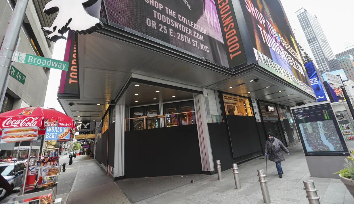 Seorang perempuan melewati sebuah toko yang dipasangi papan pelindung di Times Square di New York, Amerika Serikat pada 1 November 2020. Langkah itu dilakukan saat para peretail berupaya melindungi properti dari penjarahan atau kerusuhan lainnya dalam beberapa hari mendatang. (Xinhua/Wang Ying)