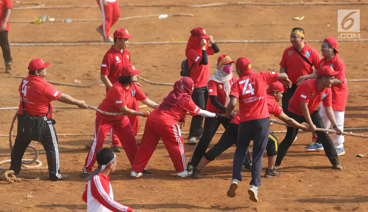 Aparatur Sipil Negara (ASN) Kementerian Dalam Negeri sekuat tenaga menarik lawan dalam lomba tarik tambang di Lapangan Banteng, Jakarta, Jumat (2/8/2019). Kemendagri memecahkan rekor MURI lomba tarik tambang dan balap kelereng eksekutif  antar aparatur sipil negara . (Liputan6.com/Angga Yuniar)