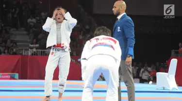 Atlet Jujitsu putri Indonesia Simone Julia terlihat kecewa saat bertanding melawan Tsogkhuu Udval dari Mongolia pada nomor final putri 62 kg Asian Games 2018, Jakarta, Sabtu (25/8). Simone gagal mempersembahkan medali perunggu. (Merdeka.com/Arie Basuki)