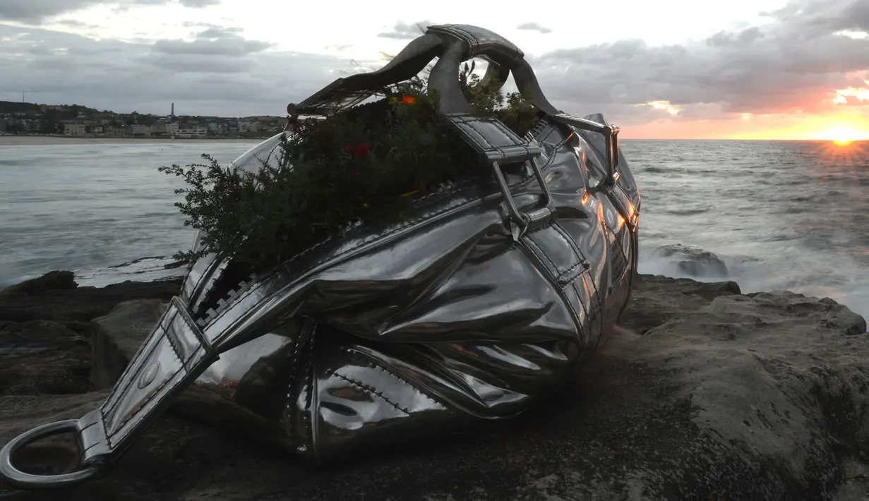 Sebuah patung berbentuk tas raksasa dipamerkan di pantai Bondi hingga Tamarama di Sydney, Rabu (19/10). Pameran yang bernama ‘Sculpture by the sea’ merupakan pameran patung tahunan diluar ruangan yang terbesar di Australia. (PETER PARKS/AFP)